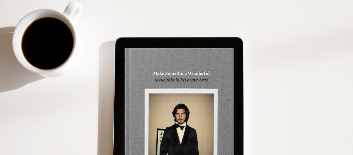 A cup of coffee and a tablet featuring the ebook "Make Something Wonderful"