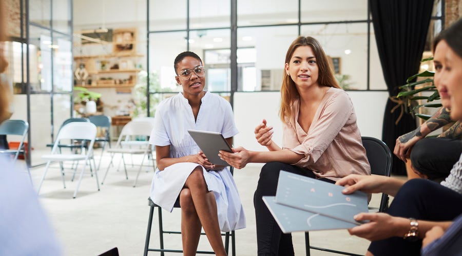 Young woman speaking in a group meeting.