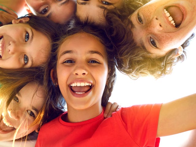Grupo de niños sonriendo en un día soleado.