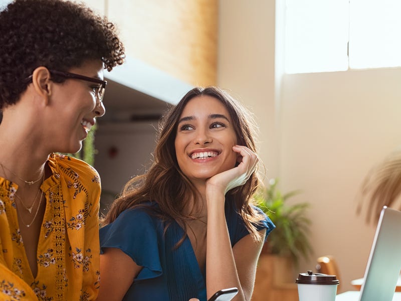 Two female friends resting and talking in a cafe.