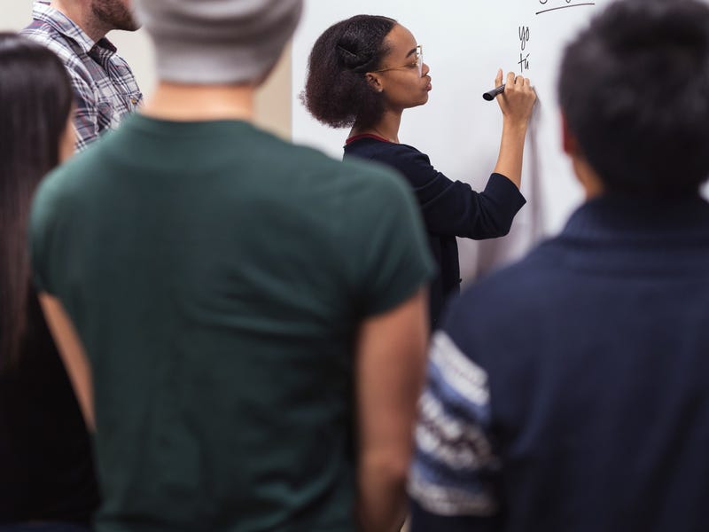 A group of students paying attention to their teacher teaching them a language.