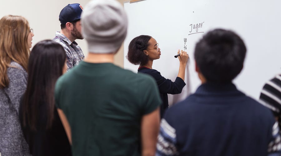 A group of students paying attention to their teacher teaching them a language.