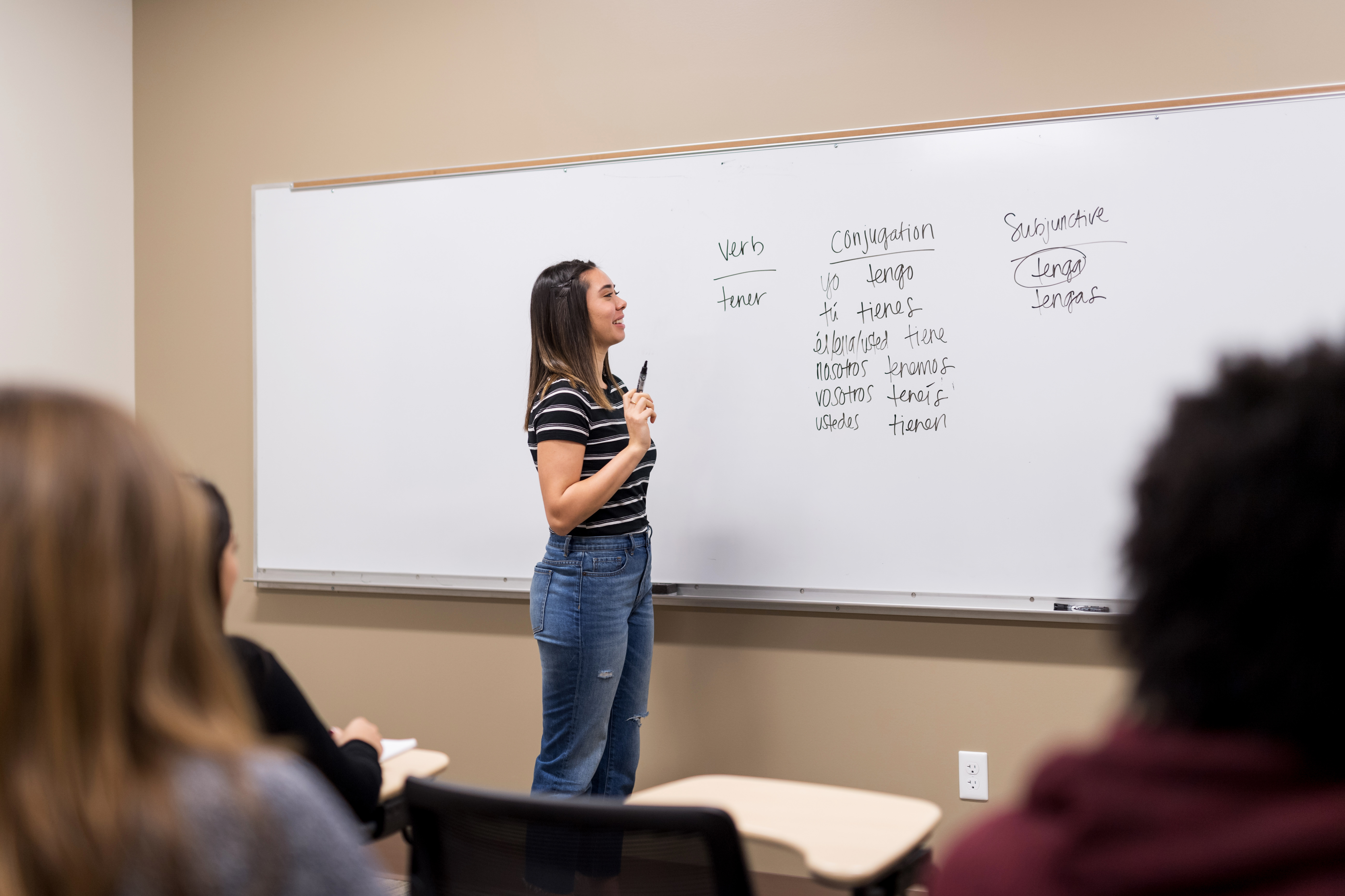 Student practicing a language exercise in front of the class.