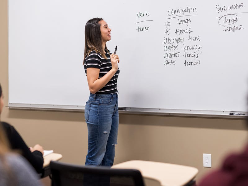 Student practicing a language exercise in front of the class.