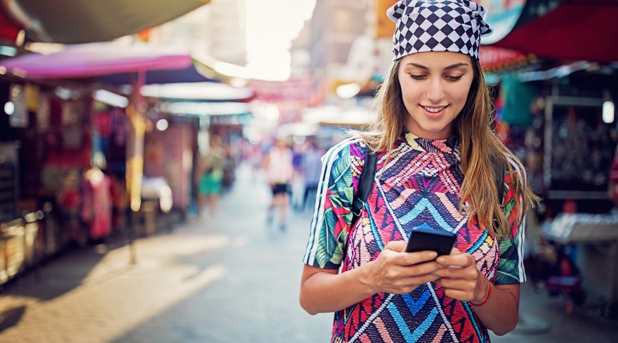 Girl chatting on her phone while walking on the street.