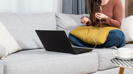 Woman with headphones taking an online language class where her instructor uses the Berlitz Method