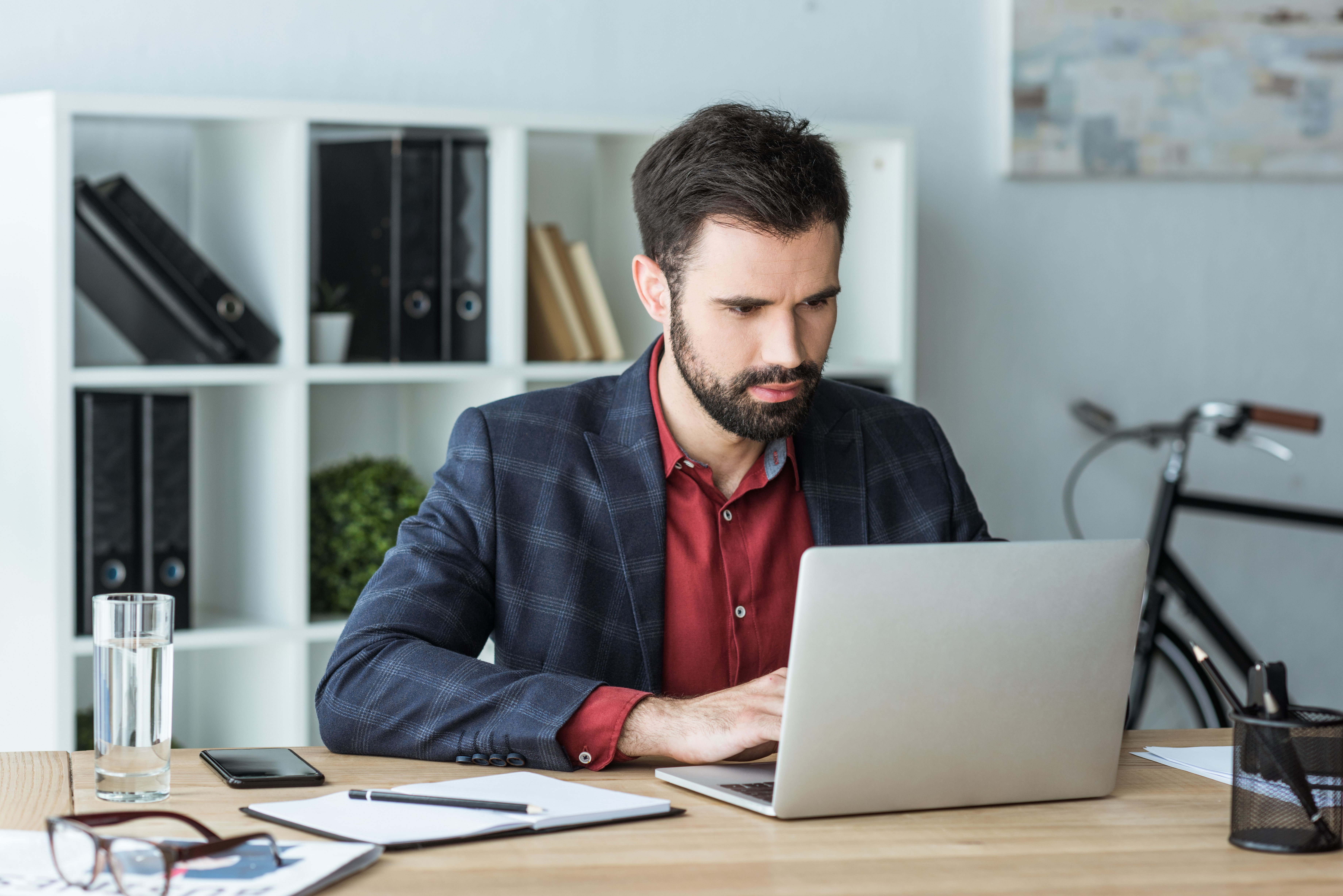 Businessman in his office sitting at his desk and learning a language with Berlitz's On Demand self-study course