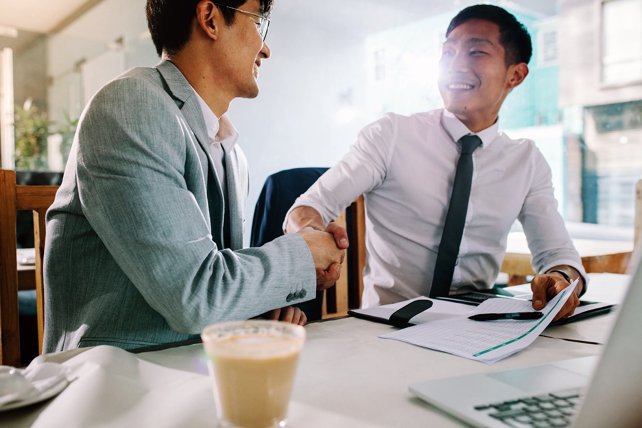 Two businessmen shaking hands and thanking each other for coming to a meeting