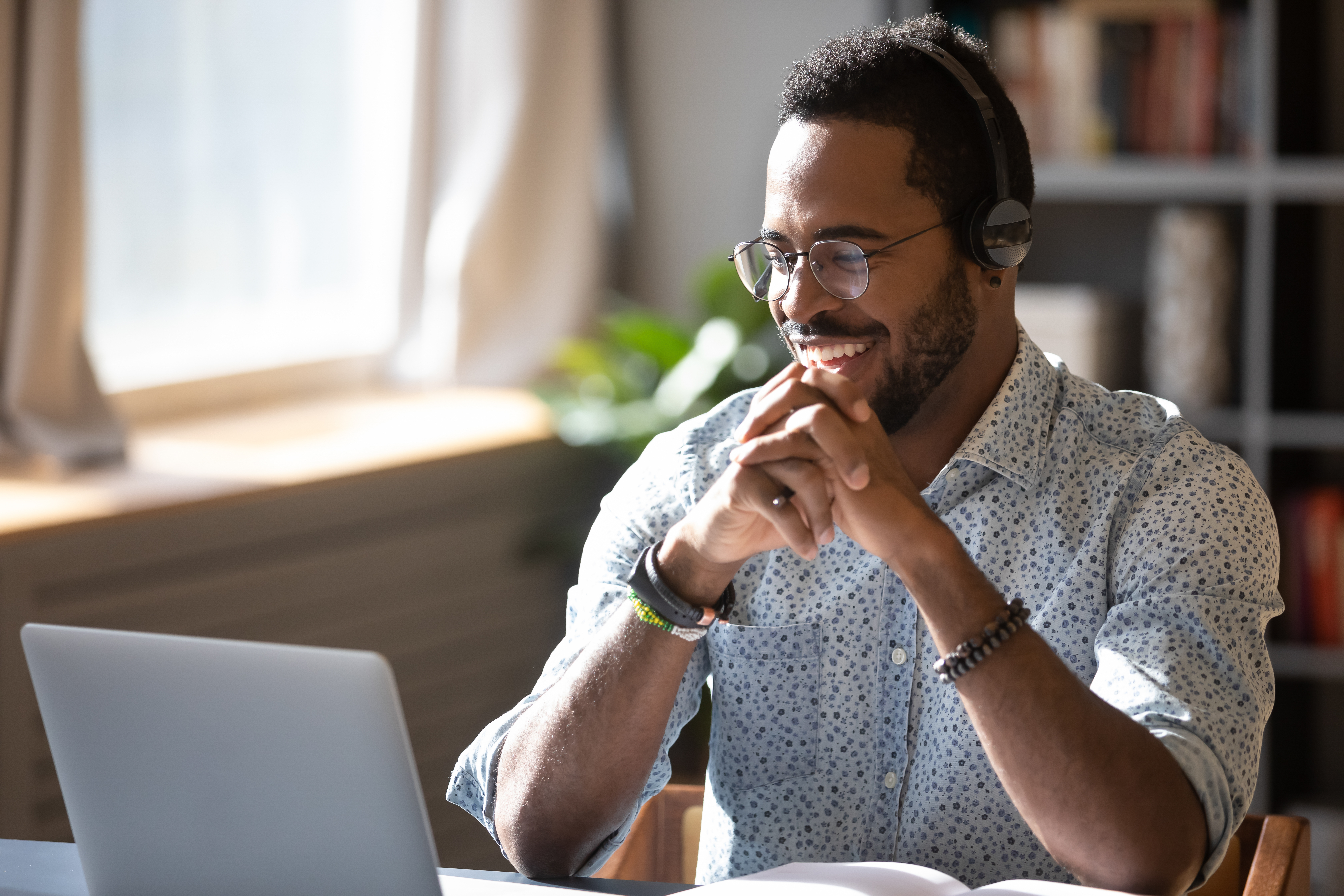 Man in headphones sitting in front of his laptop and learning a new language with Berlitz Flex