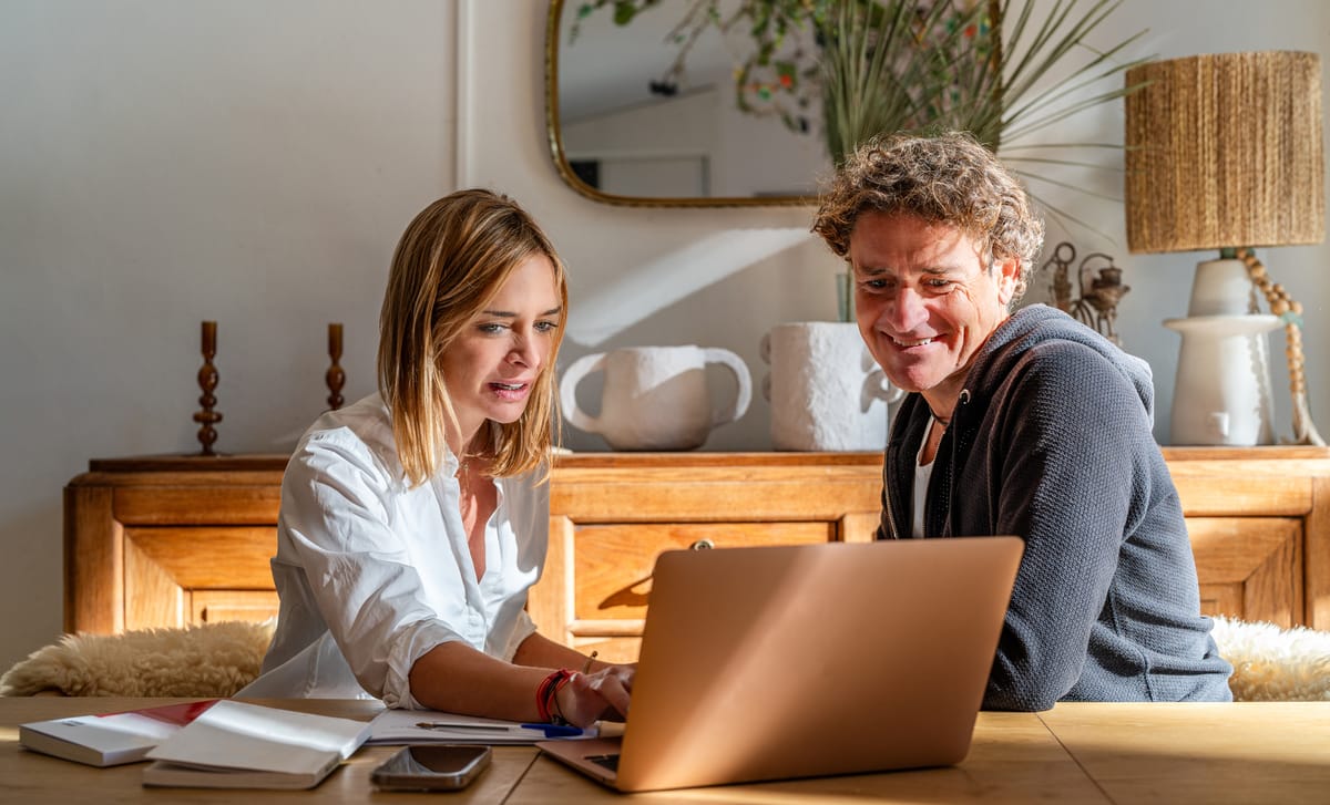 Man and woman sitting in fron of a laptop and talking to each other during a Russian class with Berlitz