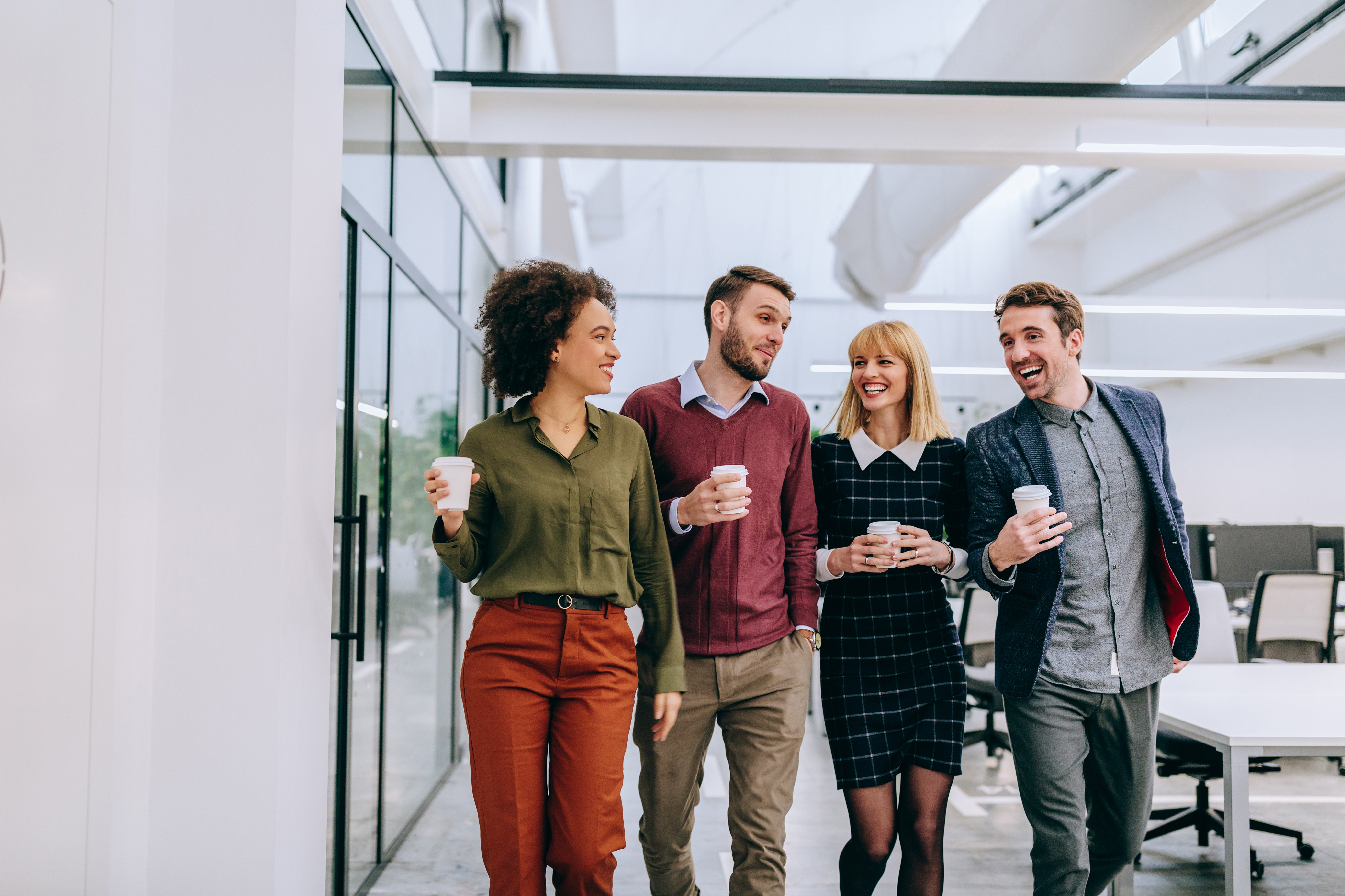 Group of friends holding coffee cups on their way to language learning with Berlitz Czechia