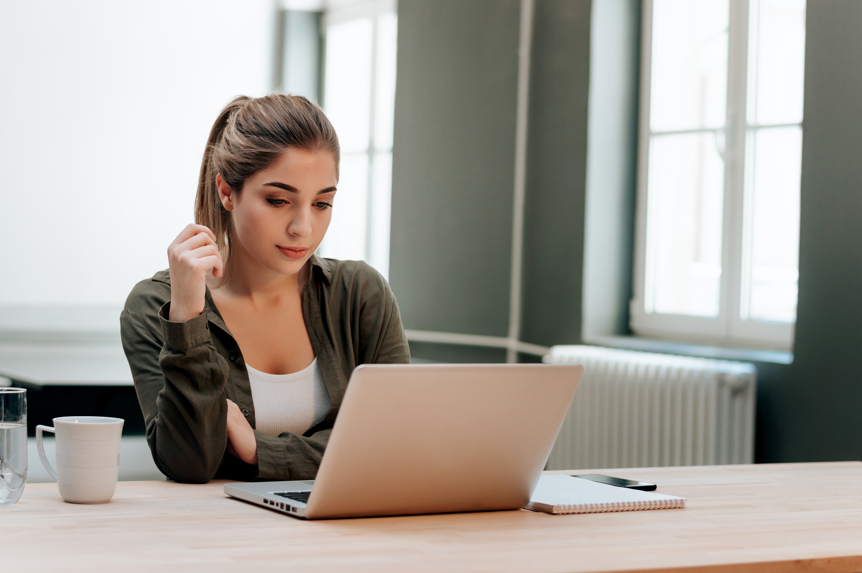 Woman in front of a laptop reading about how learning with Berlitz works