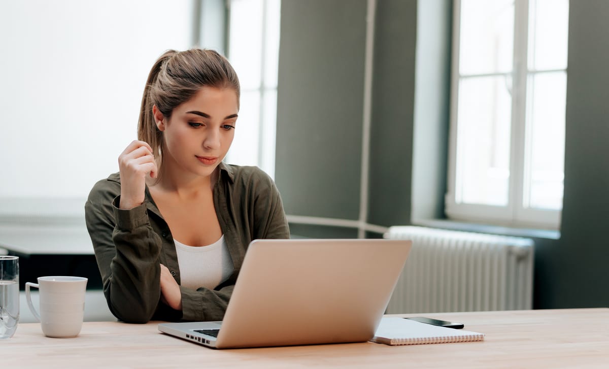 Woman in front of a laptop reading about how learning with Berlitz works