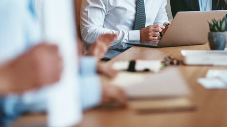 Two colleagues sitting next to each other after their corporate German courses and going through a document together