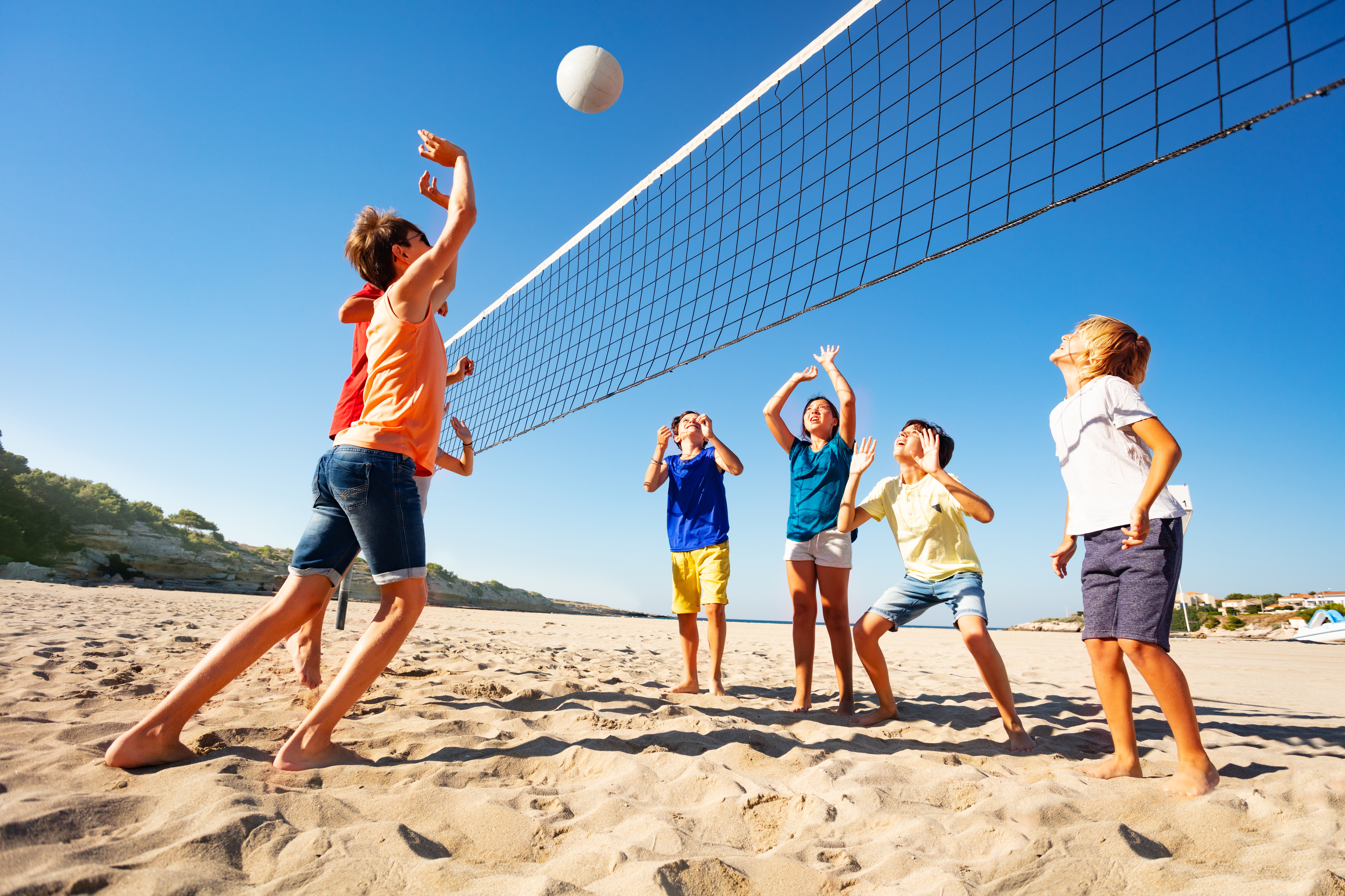 Kids playing volleyball during their international camp with Berlitz
