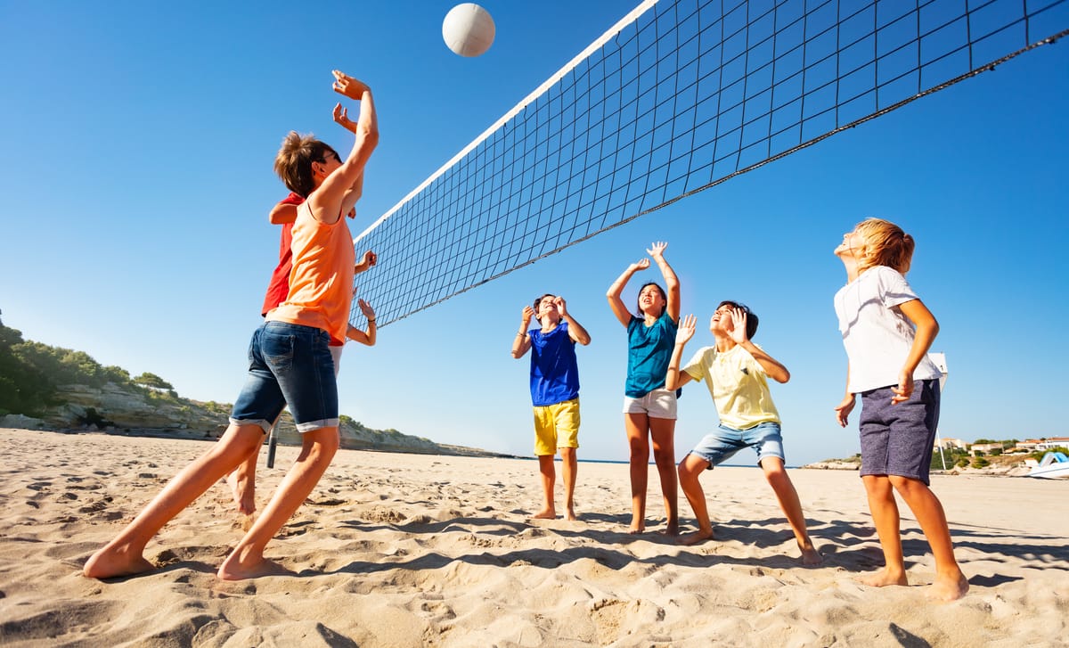 Kids playing volleyball during their international camp with Berlitz