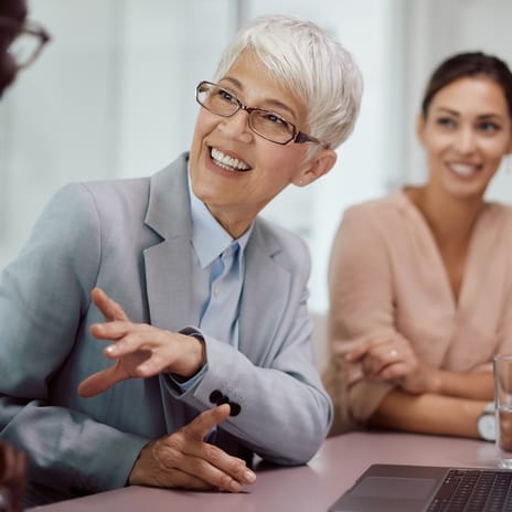 Instructor sitting next to her students and talking to them in their target language