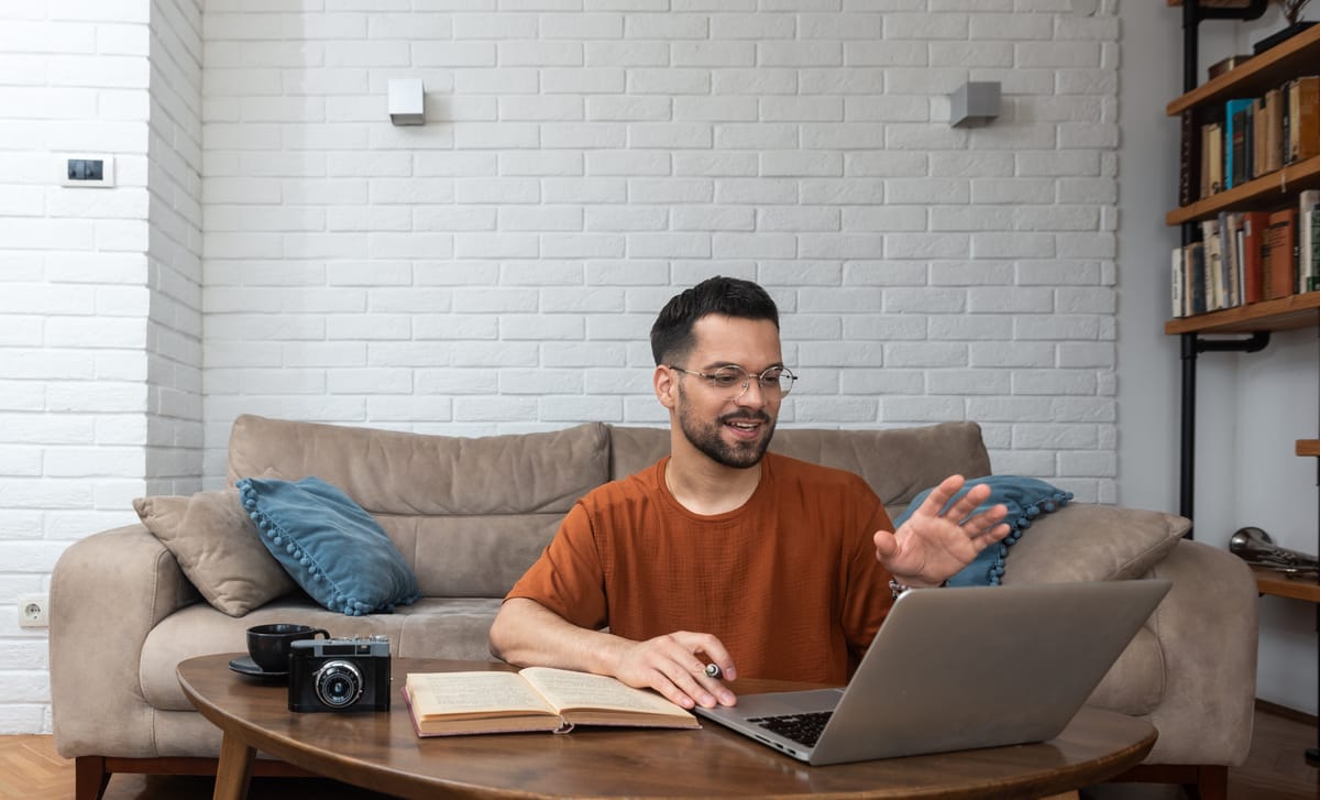 Man in his living room attending an online language lesson after he learned about Berlitz