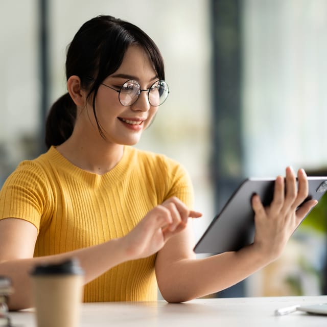 Woman in glasses filling out the online placement test to find out her current language level