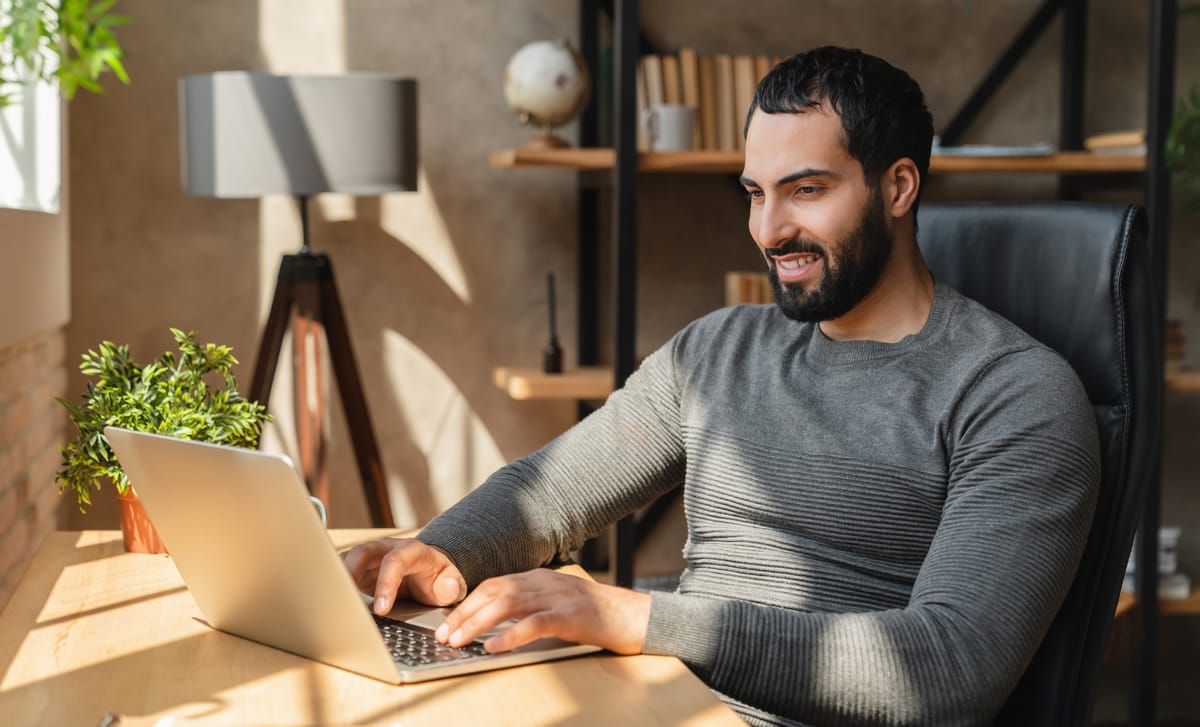 Man sitting in front of his laptop and learning a language with Berlitz's self-study platform