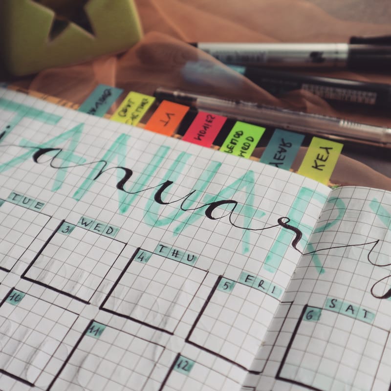 A decorated weekly planner with sticky notes showing the days of the week