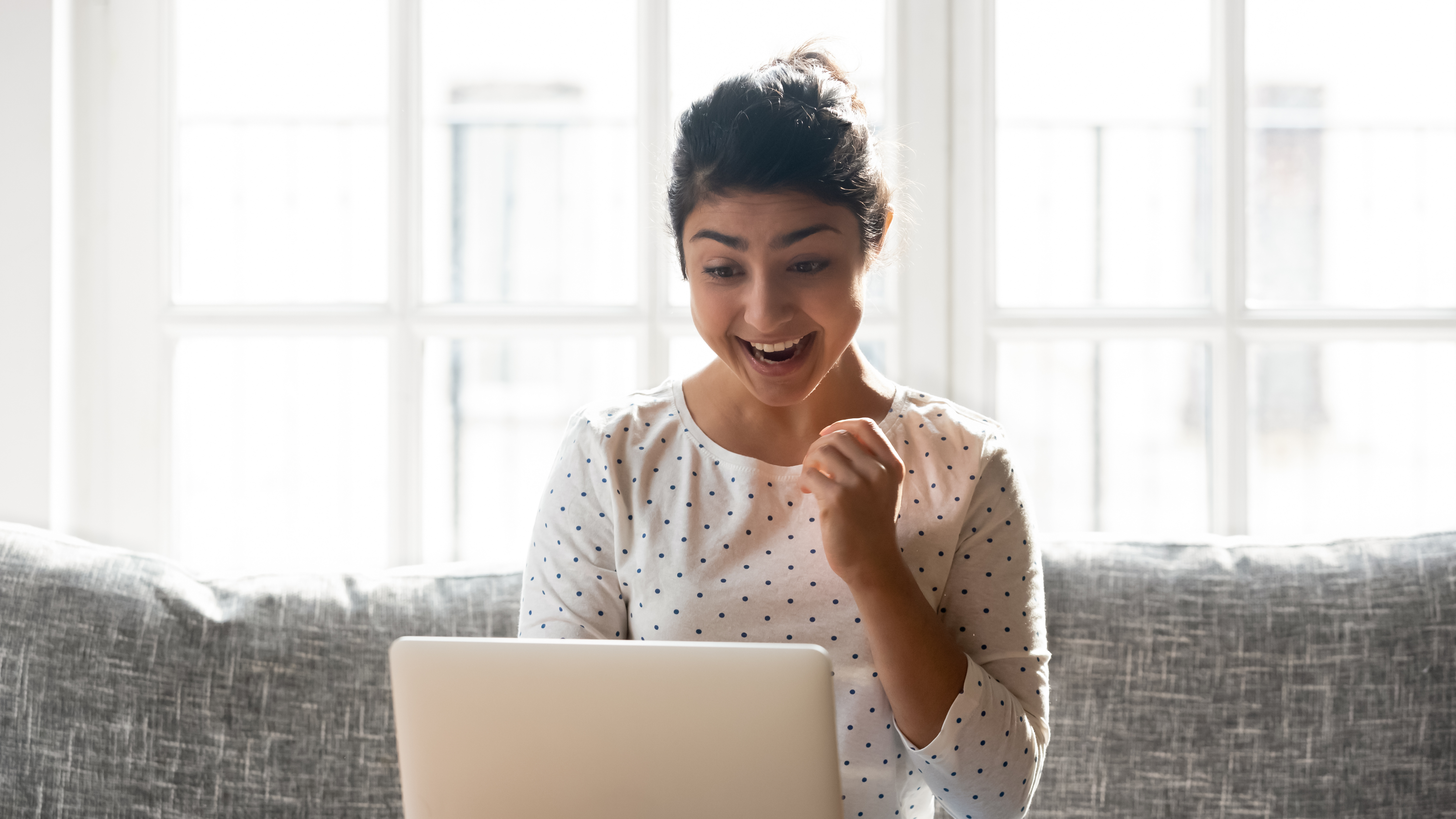 Woman in front of a laptop celebrating her milestones in Berlitz Flex
