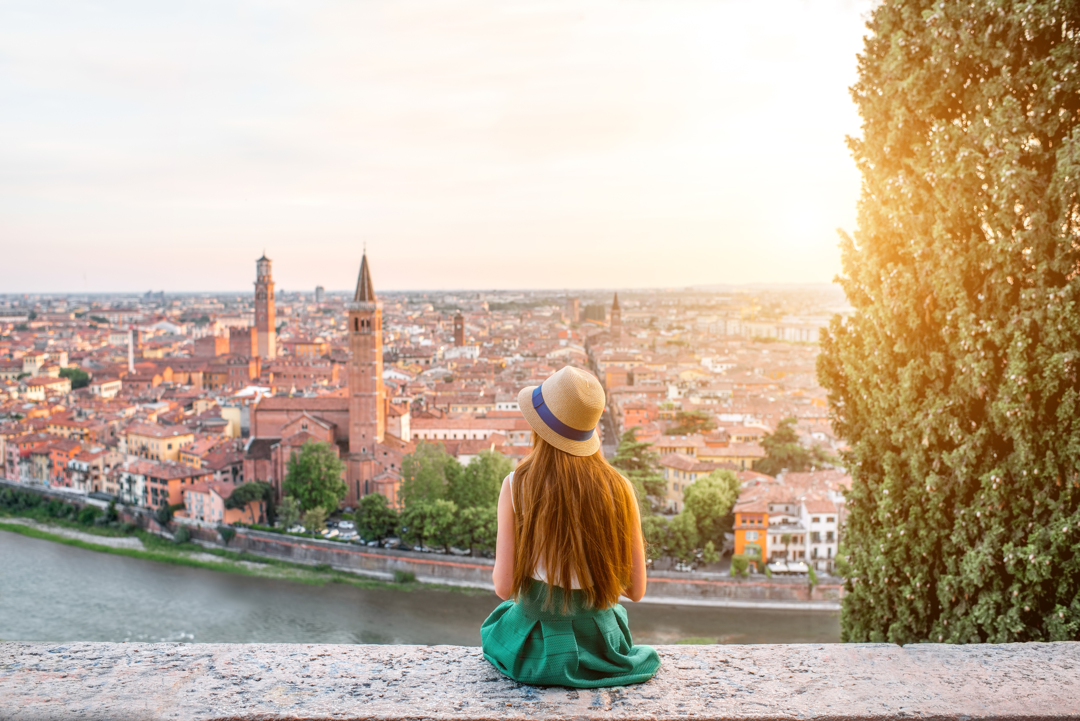 Woman sitting on the riverbank and admiring the city
