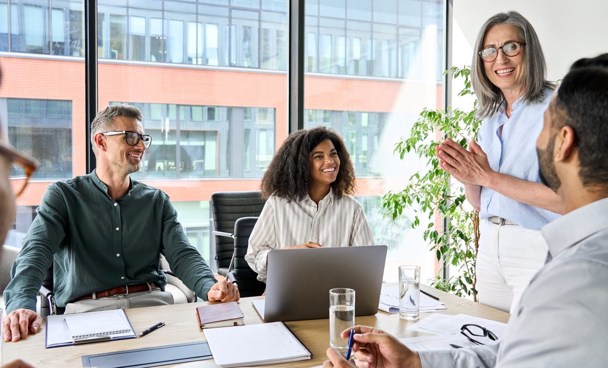 Coworkers in a meeting in an office talking to each other about their language proficiency levels