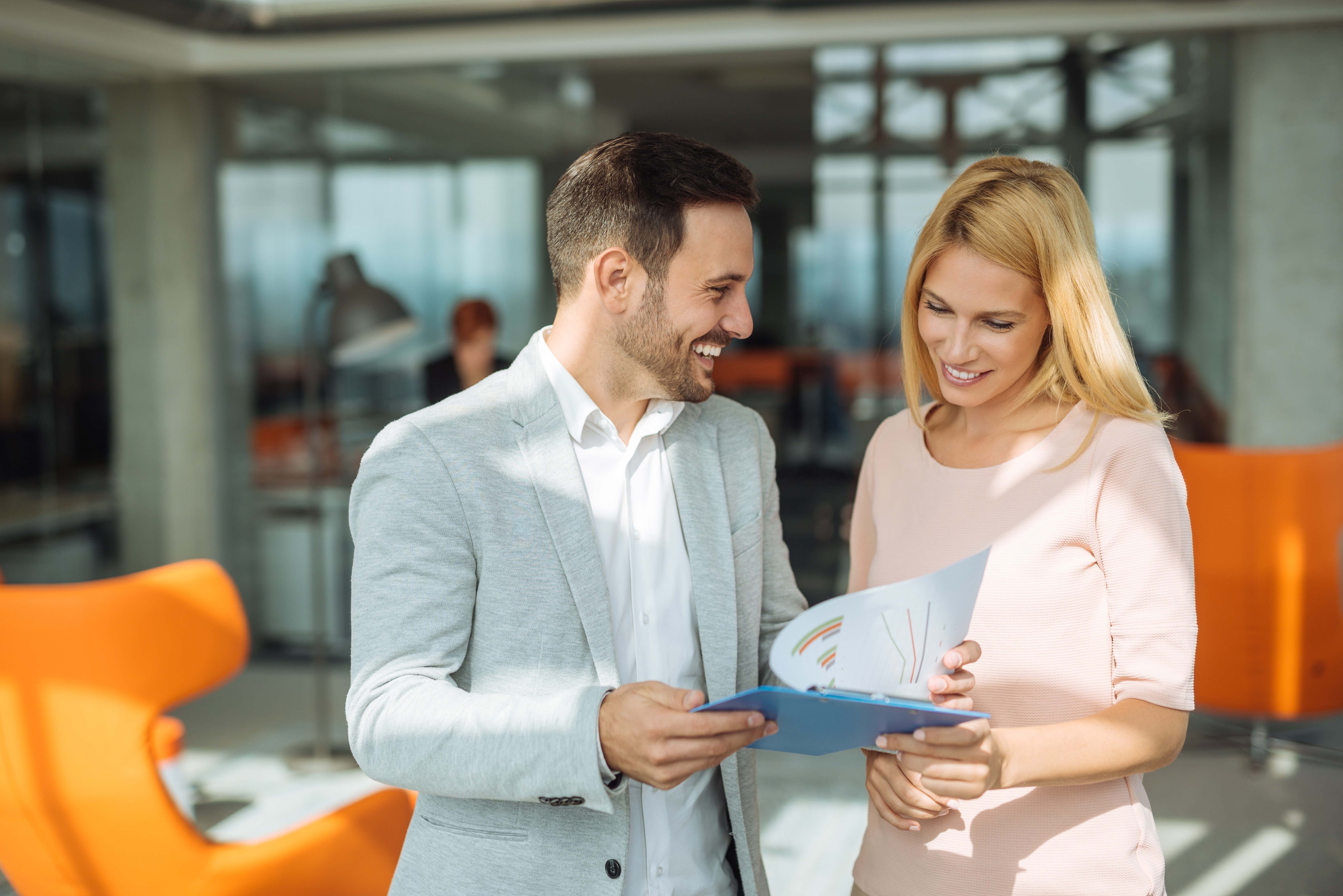 Woman using the language skills she acquired during private language lessons in her work life and checking a document with a coworker