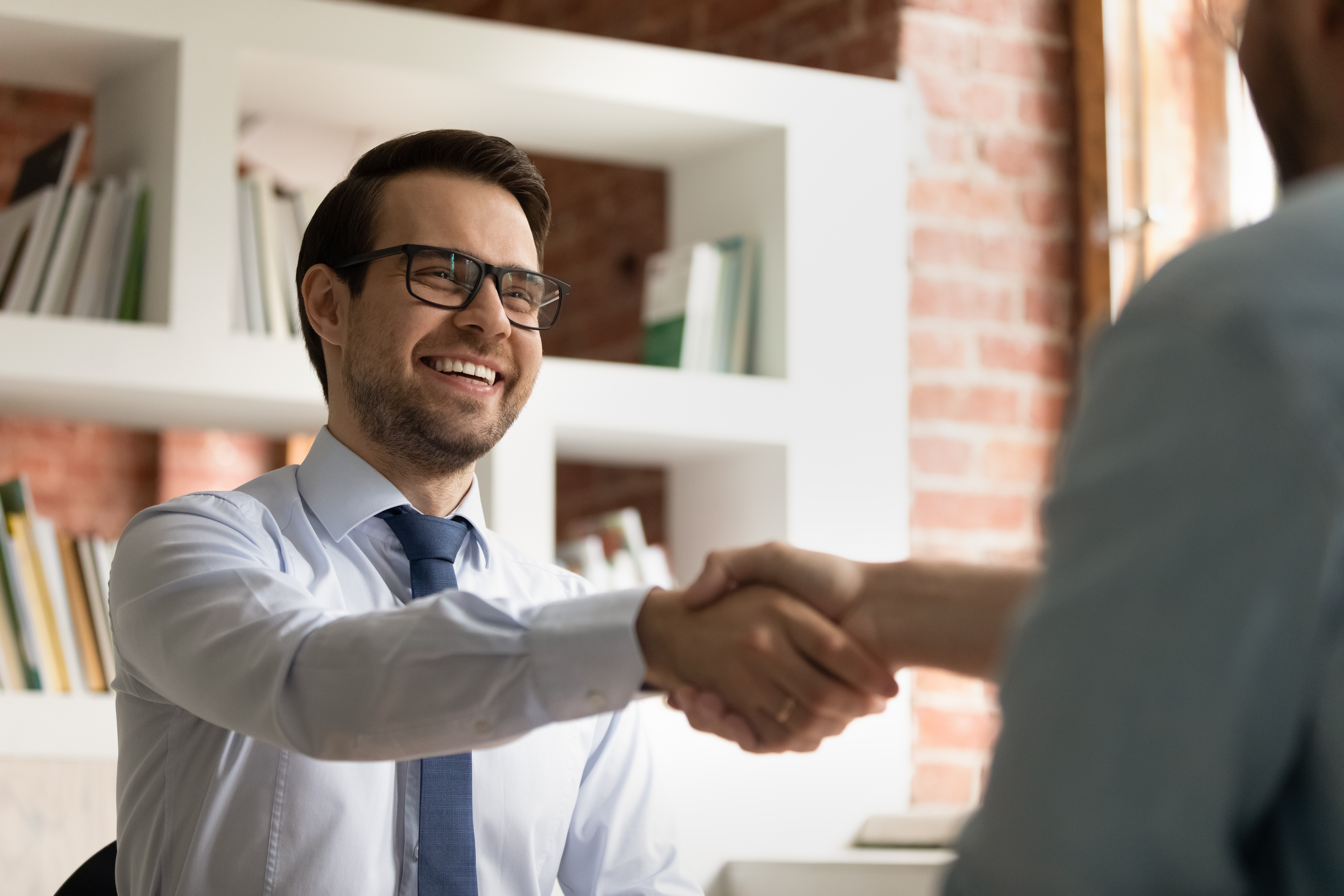 Man shaking hands with his interviewer after he applied for jobs at Berlitz