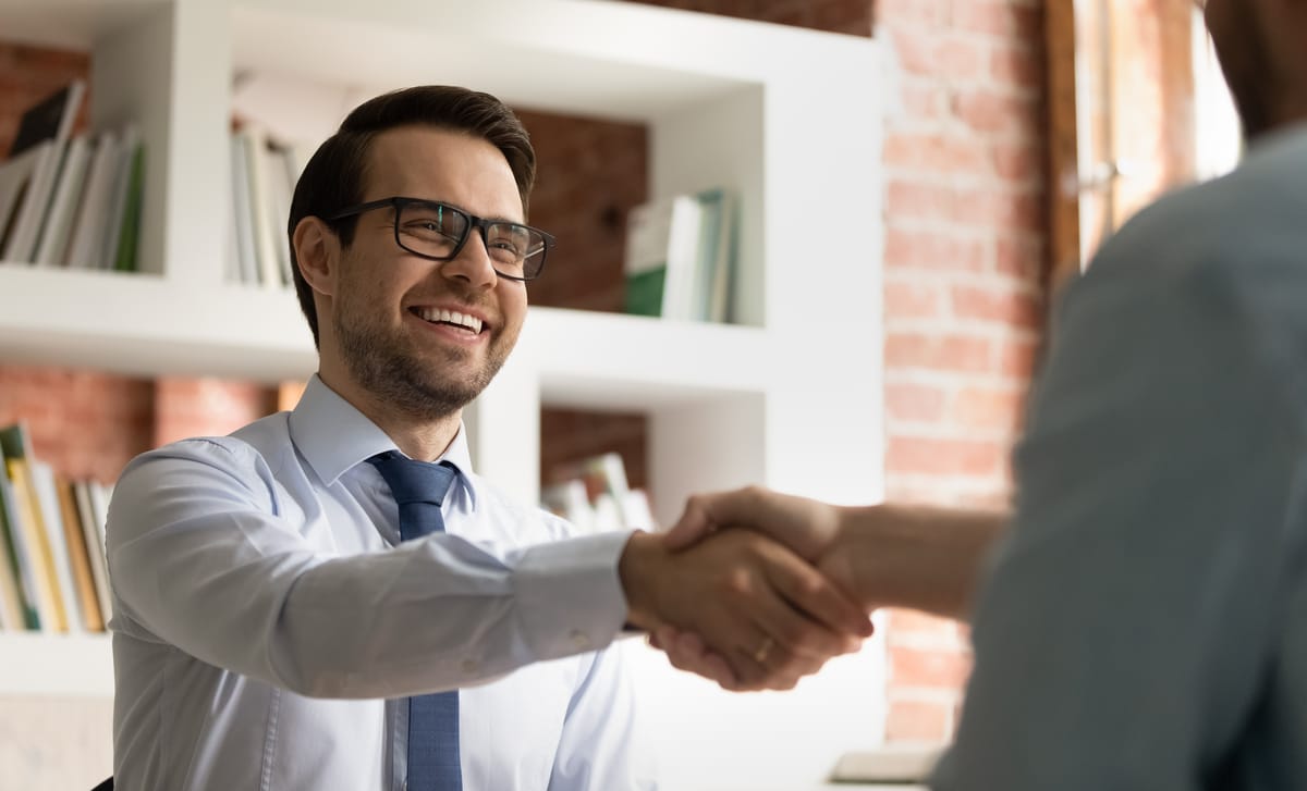 Man shaking hands with his interviewer after he applied for jobs at Berlitz