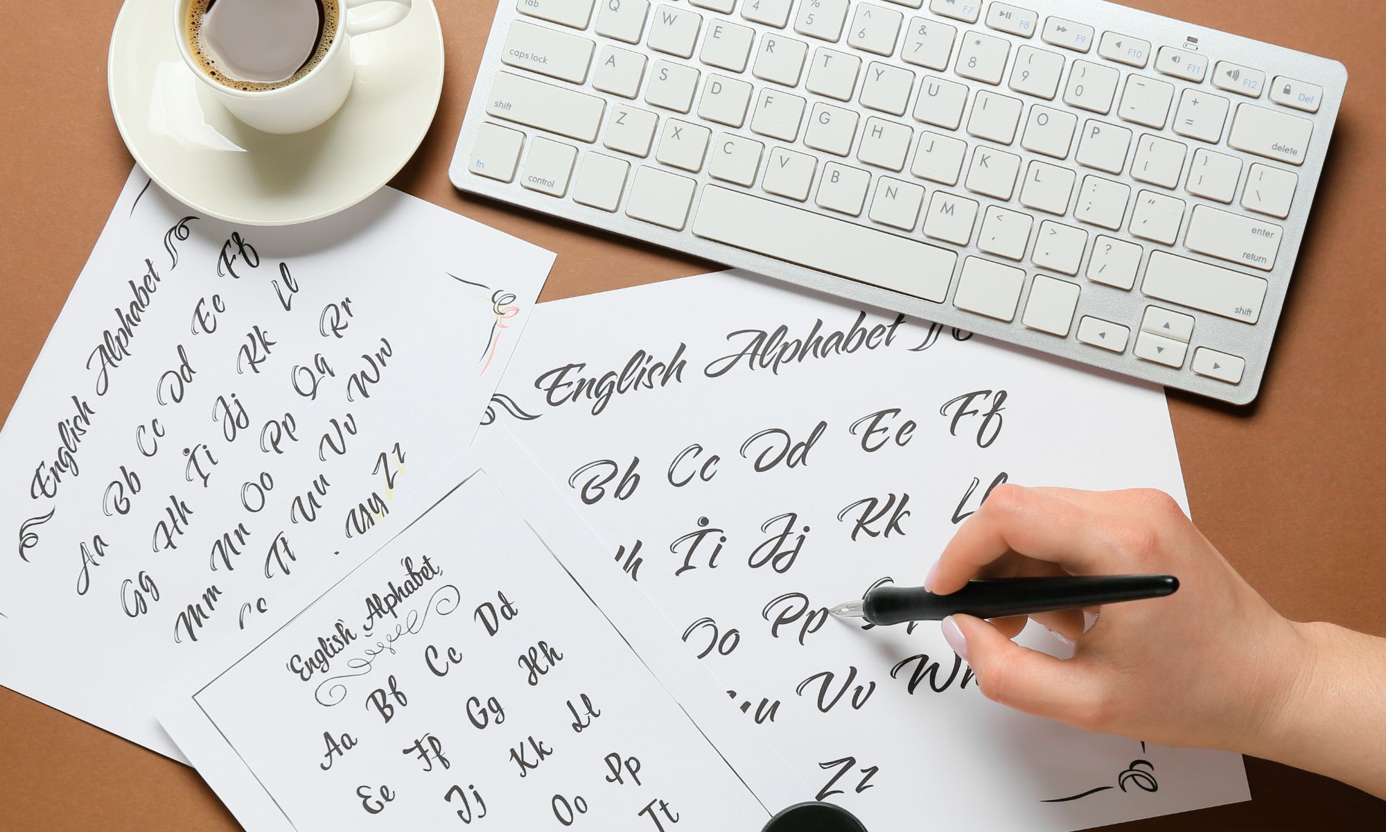 A hand writing the letters of the English alphabet on pieces of paper