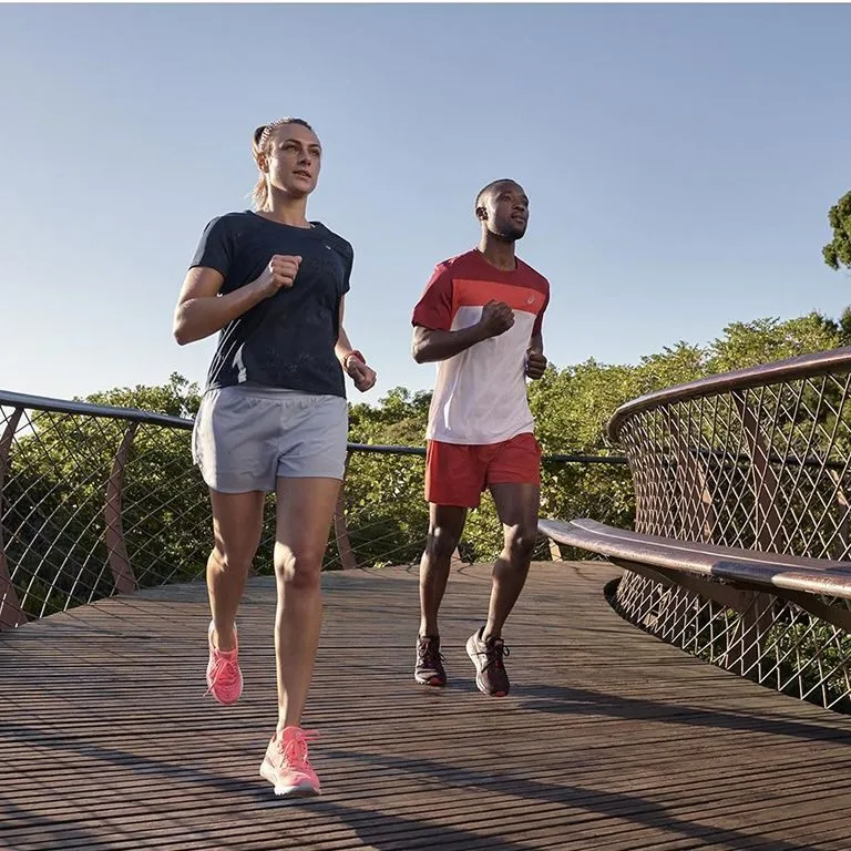 Two runners wearing ASICS shoes running outdoors