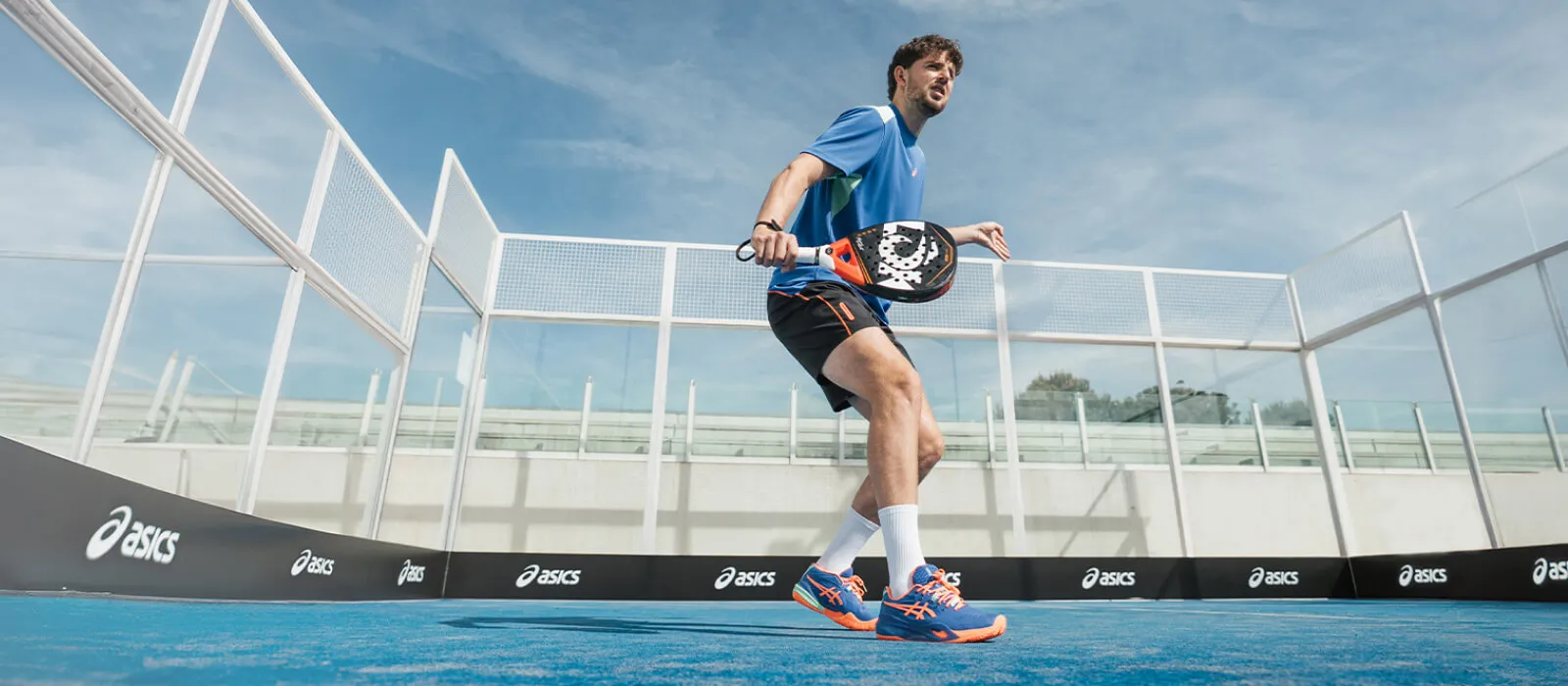 Athlete waiting for the ball on a padel court while wearing GEL RESOLUTION Padel shoes.