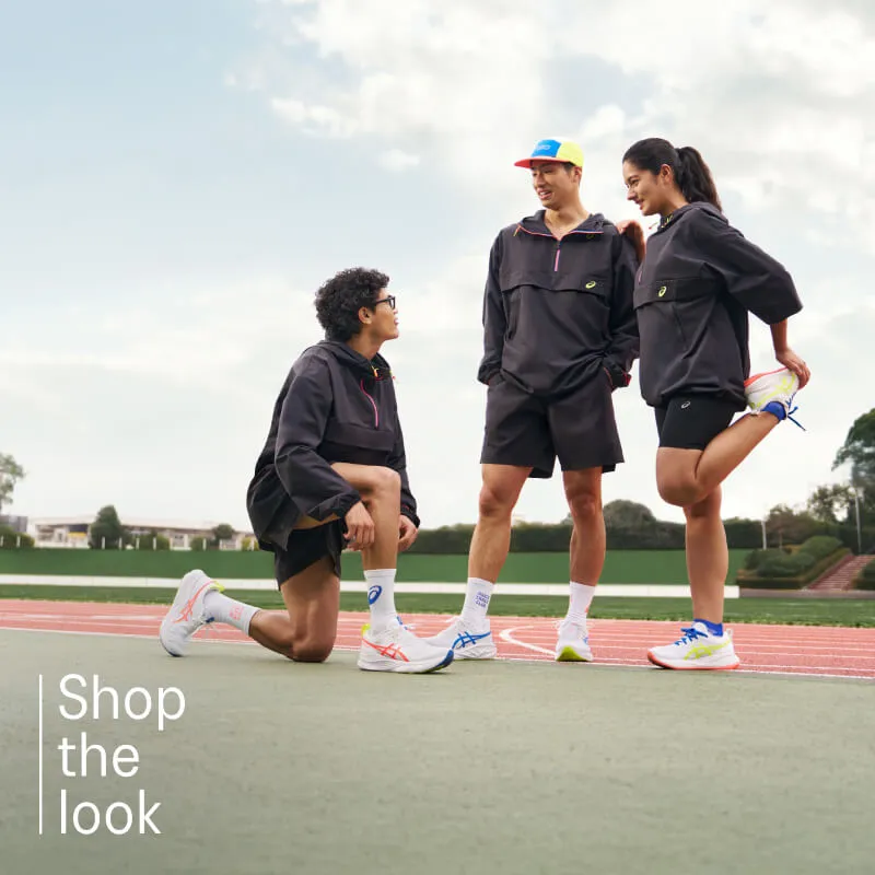 Runners standing on the field with ASICS TRACK CLUB gear