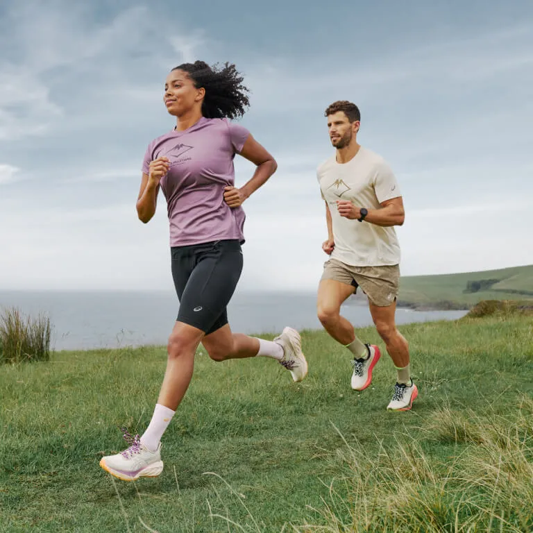 Dos personas corren usando zapatillas de correr Asics en la naturaleza