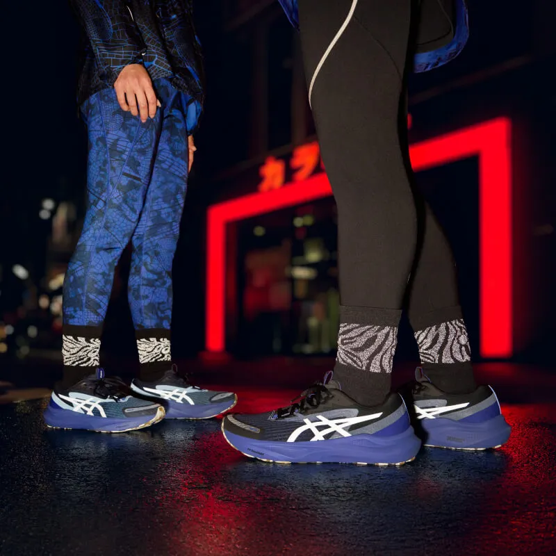 Two people wearing ASICS shoes that are reflective in the dark