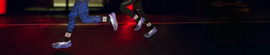 People running in the night time with reflective details on their shoes.