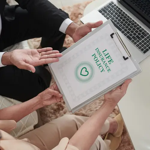 Individual being presented life insurance policy on a clipboard