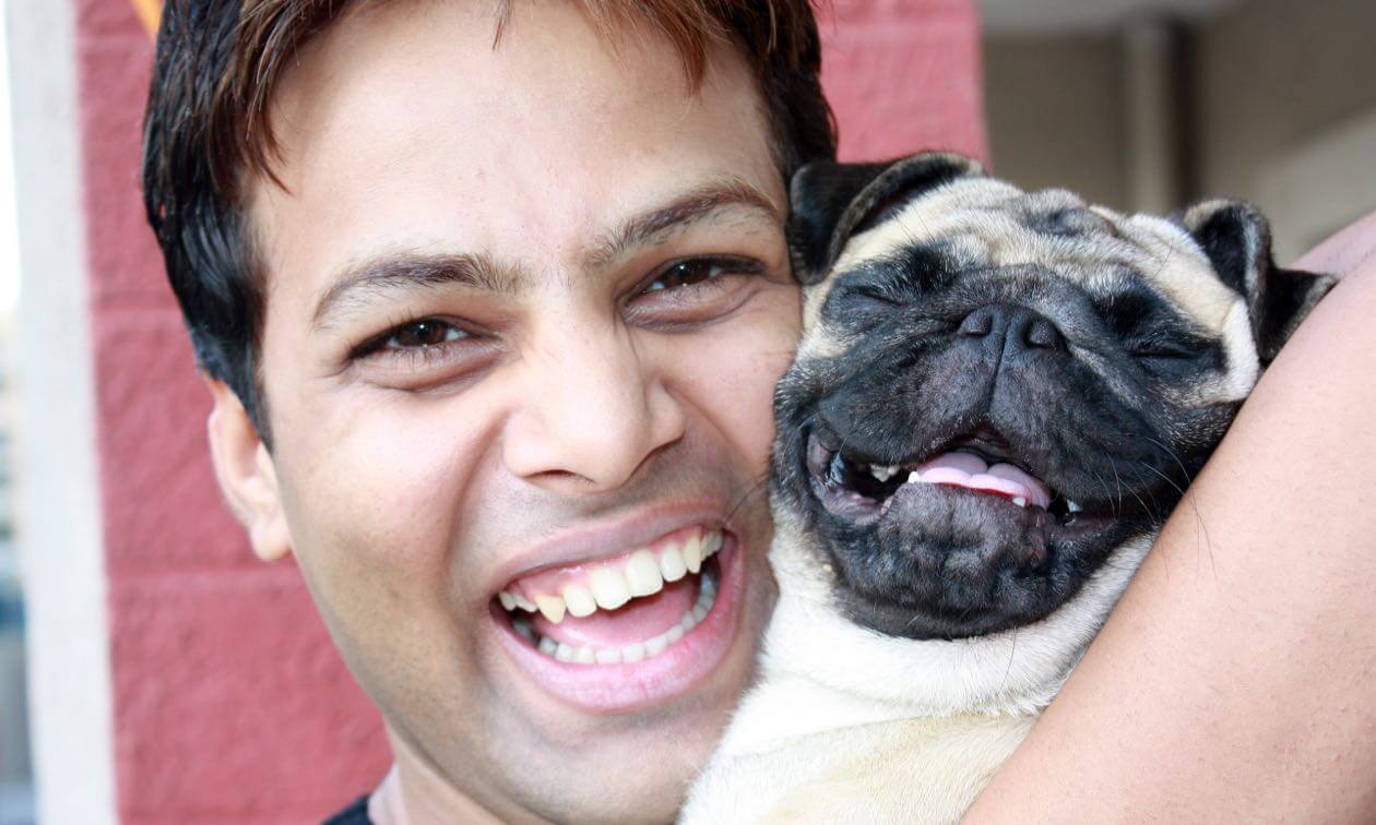 A man holding a small dog in his arms.