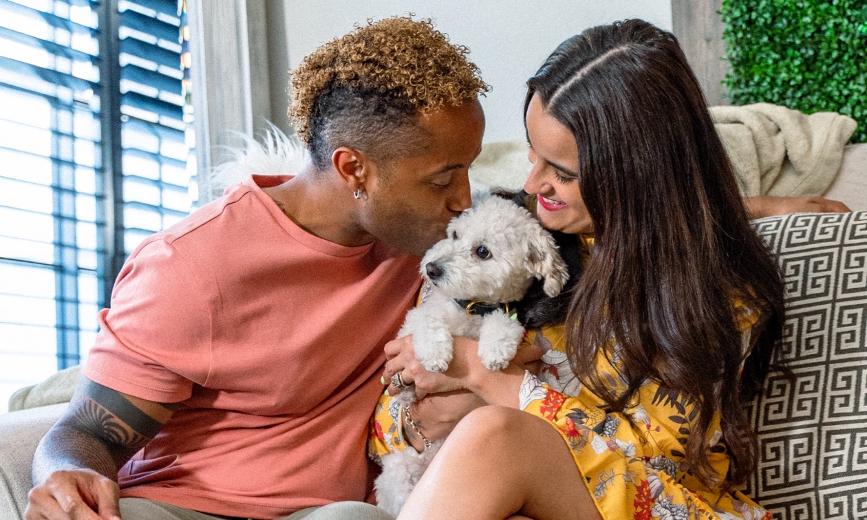 Couple cuddling with their dog.