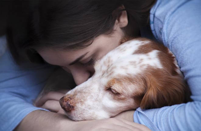 A woman holding a dog in her arms.