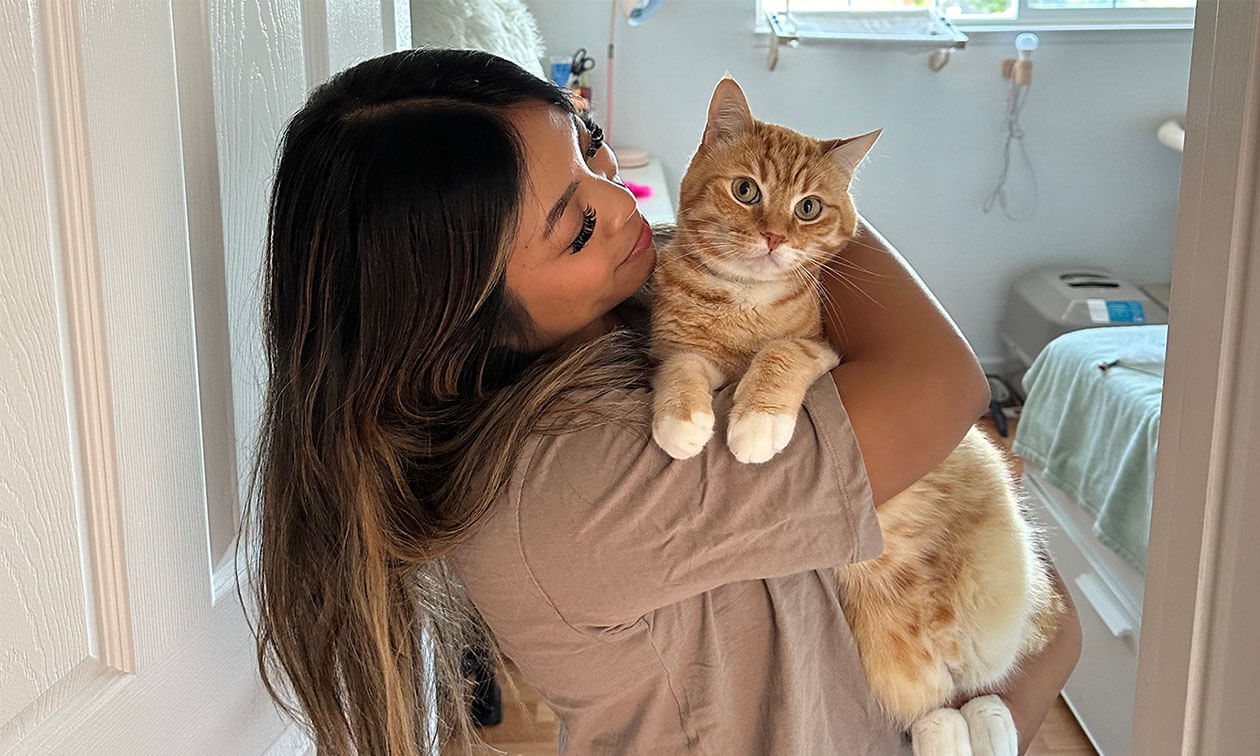A woman holding a cat in her arms.