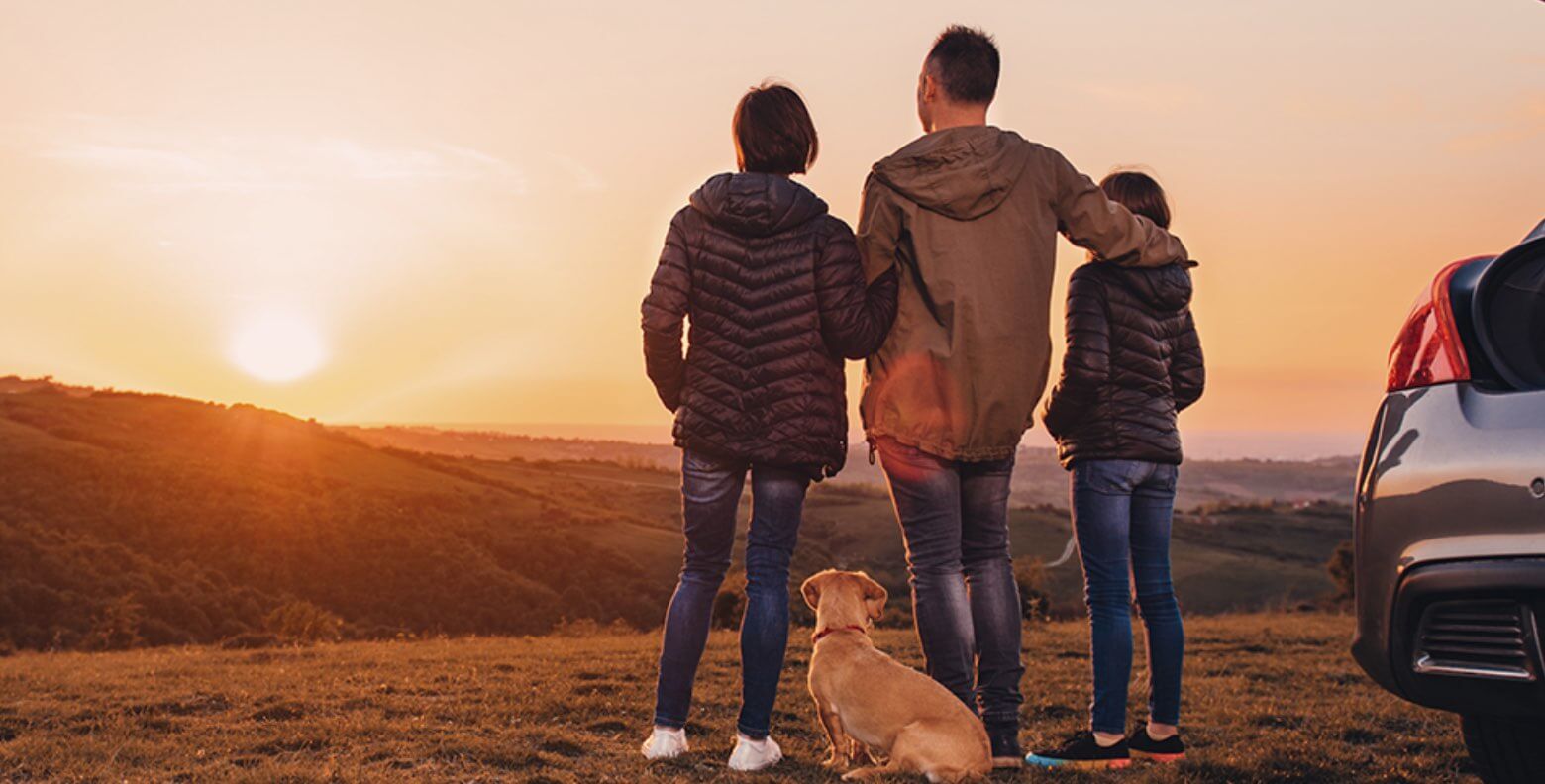 A group of people standing next to a dog.