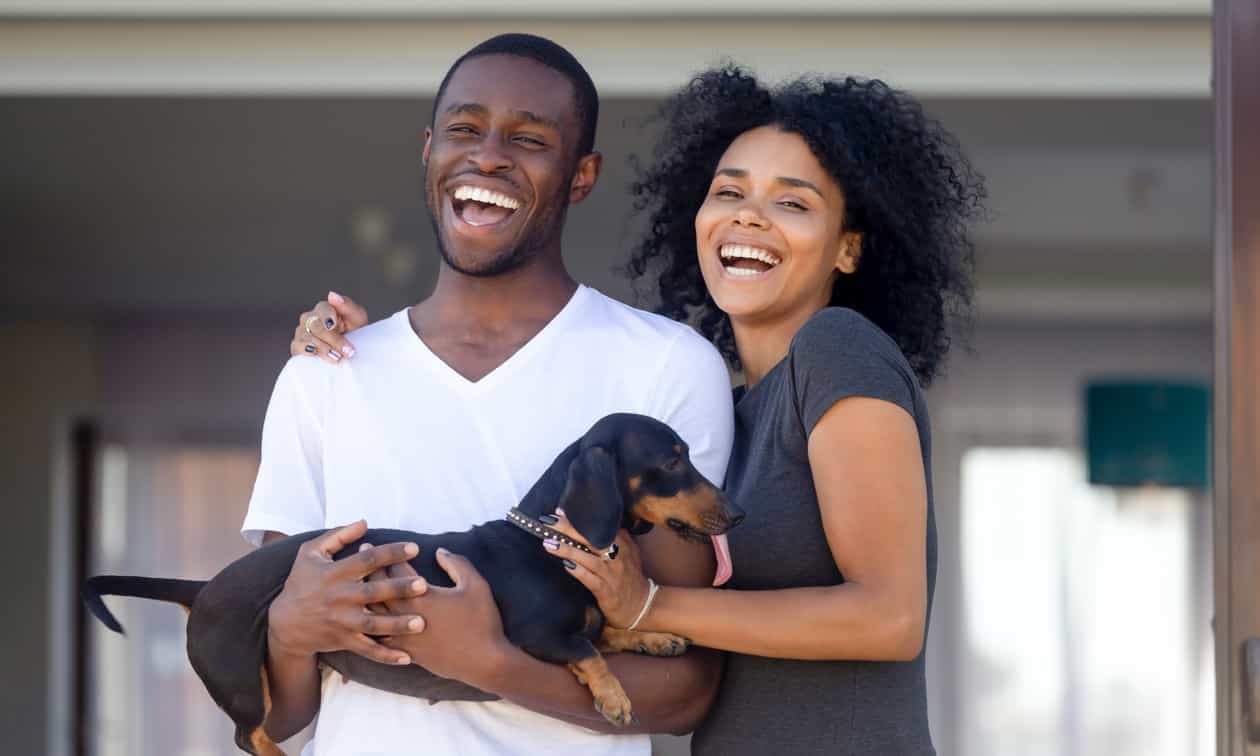 Couple smiling with their dog