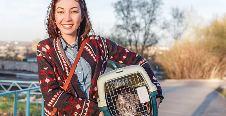Woman holding cat in cat carrier