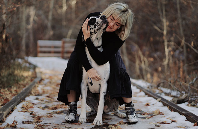 A woman hugging a dalmatian dog.