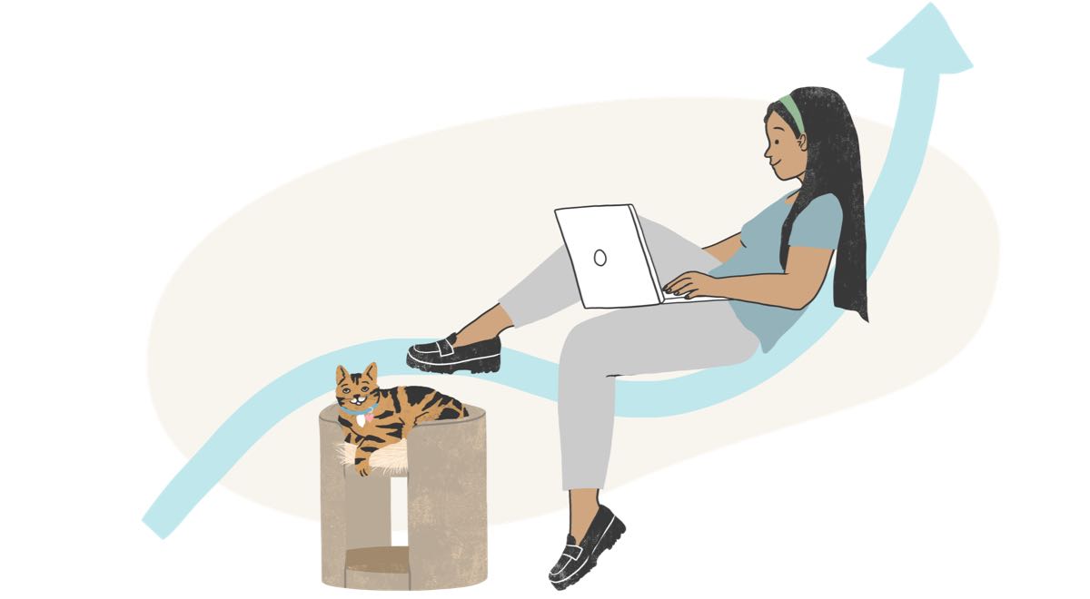 Woman working on a laptop with her cat