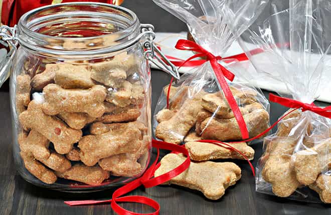 A glass jar filled with dog treats on top of a table.