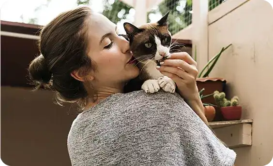 Woman giving her cat a treat